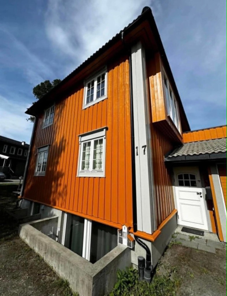 Enebolig med oransje nymalt fasade